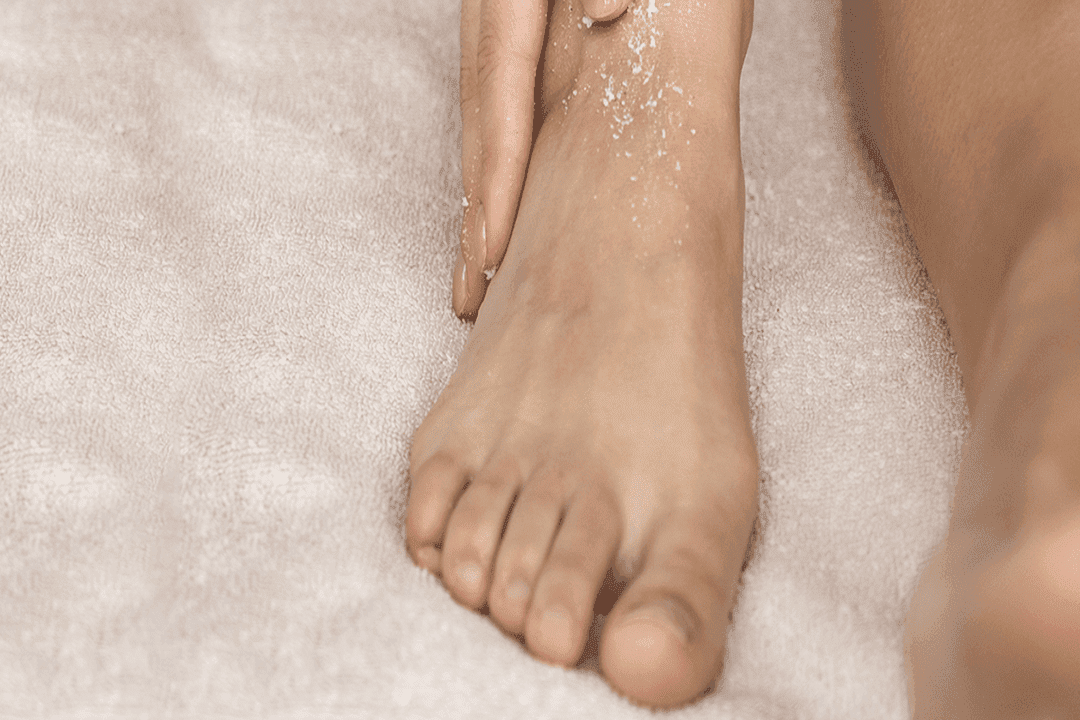 Talco nos pés: imagem mostra mulher hidratando seus pés.